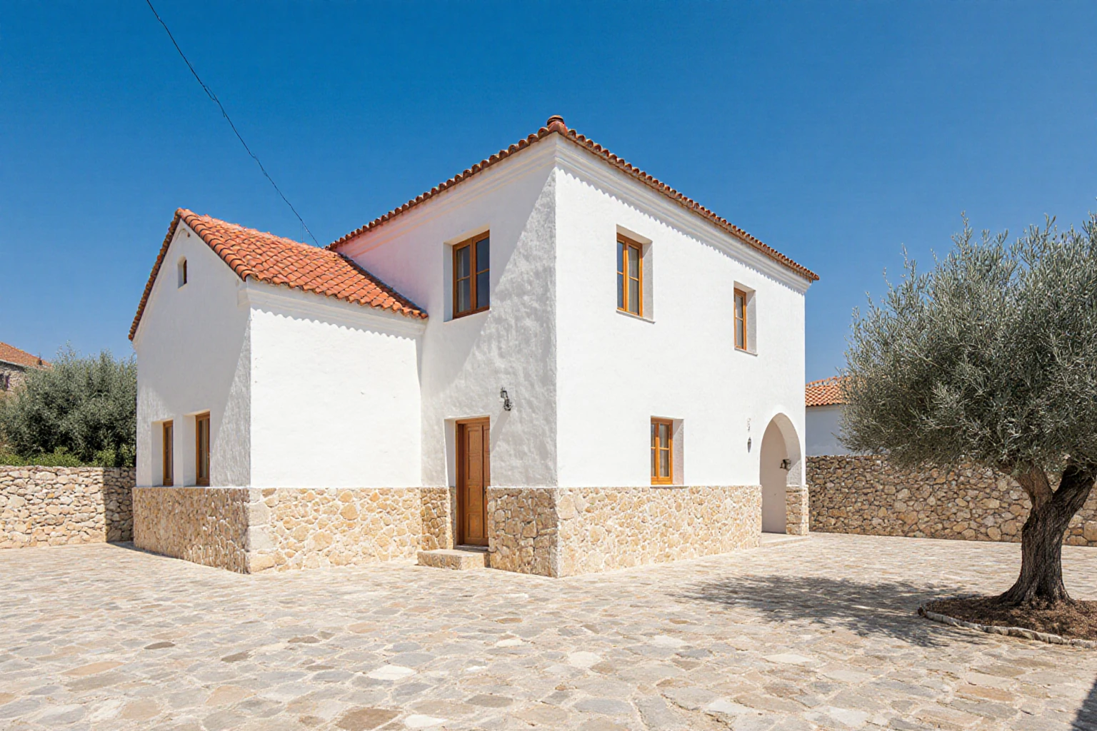 Stone and plaster house with an olive tree in its courtyard
